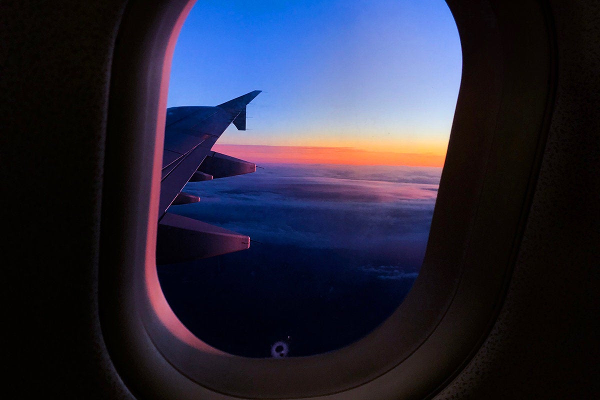 Passenger view of an airplane wing above the clouds. / travel / journey / transportation